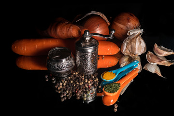 Old vintage pepper mill, pepper grains, spoons with spices and fresh organic vegetables with...