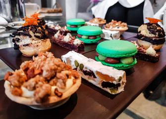 Luxury afternoon tea with macaroons and delicious desserts like nougat and healthy nuts. Close up of a popular high tea in England. 