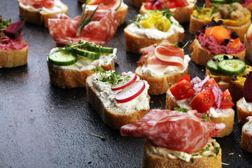 Assorted bruschetta with various toppings. Appetizing bruschetta or brie crostini. Variety of small sandwiches. Mix bruschetta on table