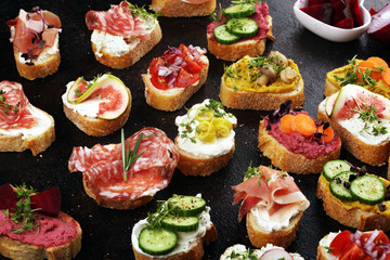 Assorted bruschetta with various toppings. Appetizing bruschetta or brie crostini. Variety of small sandwiches. Mix bruschetta on table