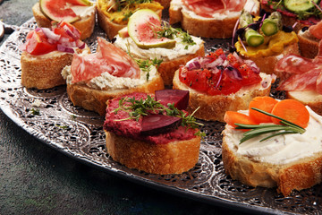 Assorted bruschetta with various toppings. Appetizing bruschetta or brie crostini. Variety of small sandwiches. Mix bruschetta on table