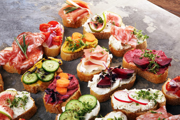 Assorted bruschetta with various toppings. Appetizing bruschetta or brie crostini. Variety of small sandwiches. Mix bruschetta on table