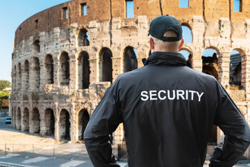 Man In Security Uniform Standing Near Coliseum In Rome