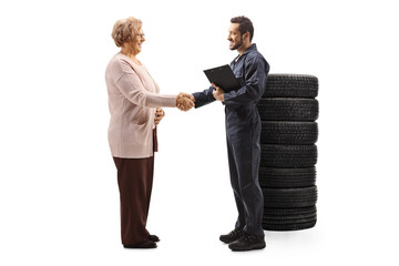 Auto mechanic shaking hand with an elderly woman