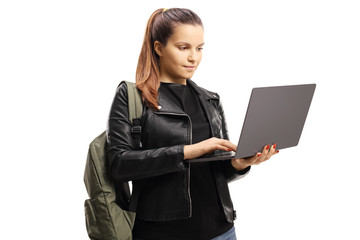 Female student standing and using a laptop computer