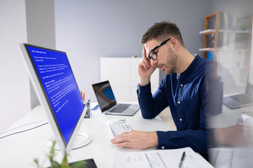 Worried Man At Computer With System Failure On The Screen