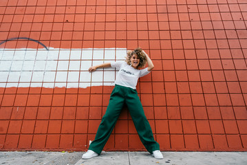 Woman posing in front of orange wall