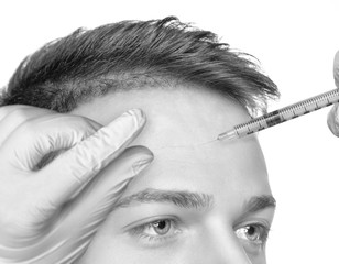 Obraz premium The doctor cosmetologist makes the Rejuvenating injections procedure for tightening and smoothing wrinkles on the face skin of a handsome man with clean skin in a beauty salon.Cosmetology concept.