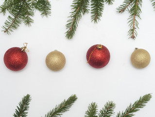 Christmas and new year composition.Top view,Two red balls and two golden balls and border from christmas tree branches on white background.