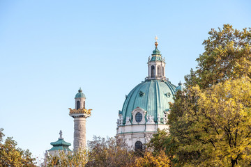 Main dome of Karlskirche on the Karlsplatz square in Vienna, Austria surrounded by autumn trees. It is a catholic church, also called Rektoratskirche, with a typical baroque architecture