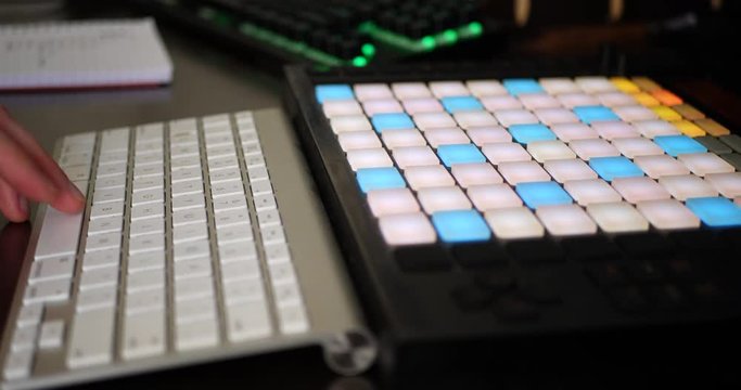 A hip hop music producer making a rap beat in his bedroom studio with a digital instrument midi controller SLIDE RIGHT.