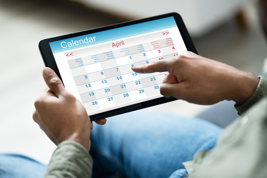 Man Using Calendar On Digital Tablet