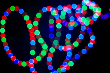 Bokeh effect on round red, green and blue circle lights. Abstract blurred leds garland for background. Festiv wallpaper.
