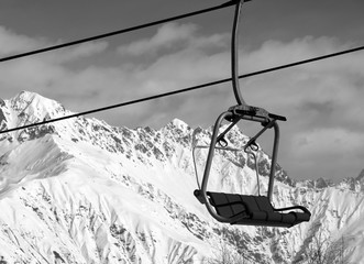 Chair lift in snowy mountains at nice sunny day