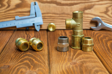 Obraz na płótnie Canvas Set of brass fittings is often used for water and gas installations on background of tools