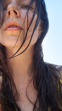 Vacation at the sea, young woman with wet hair after swimming, close-up portrait.