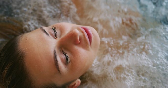 Close up of an young female is enjoying and having relax in a bath tube in a luxury wellness center.