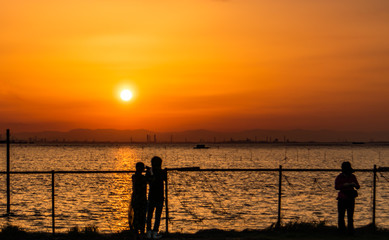 江川海岸で夕日を見る人々