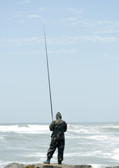 Young man fishing at sunset