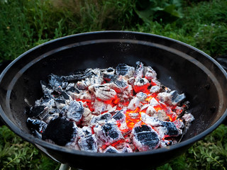 laid out burning coals in a round bowl grill on a picnic