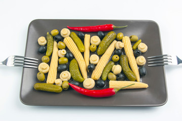 Olives, pickled cucumber, pepper, mushrooms and corn in a salad on a plate. food and vegetables. diet and weight loss