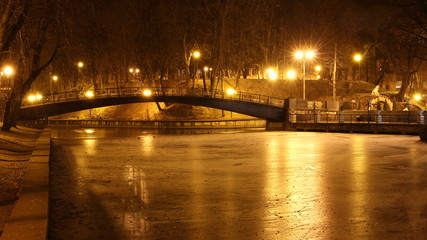 Fototapeta na wymiar Smolensk, Russia, beautiful autumn evening in Park Lopatin Garden, Gorbaty Bridge on ice Pond with glowing streetlights