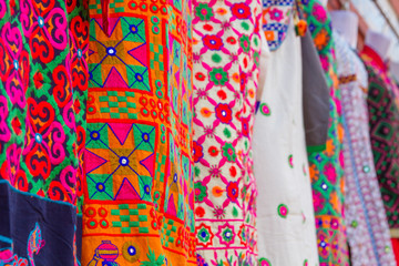 Various colorful styles of Rajasthani cloth in a marketplace in Jaipur, India.