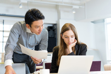 協力して仕事をする人種の違う男女