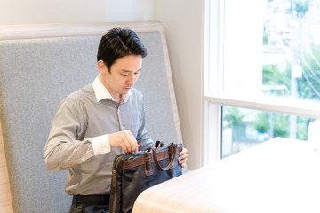 バックから荷物を取り出すビジネスマン