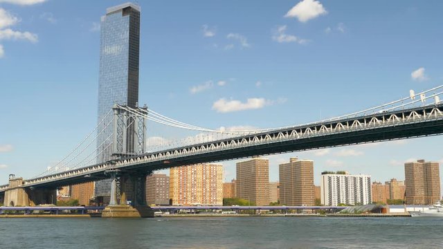 Manhatan Bridge spanning across the East River accompanied by the NYC Skyline of Buildings