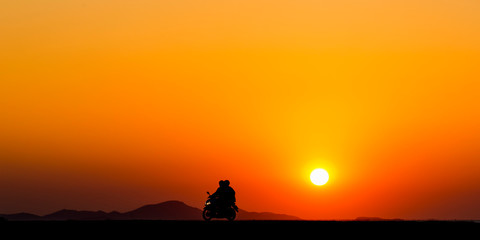 Naklejka na ściany i meble Panorama silhouette couple travelers riding motorcycle on summer rural landscape at sunset background, Tourist joy fun driving motorbike, Adventure tourism Asia holiday vacation travel trip web banner