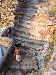 A temple priest carrying water up from the reservoir.