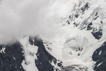 Atmospheric minimalist textured alpine landscape with massive glacier on big mountain in low...