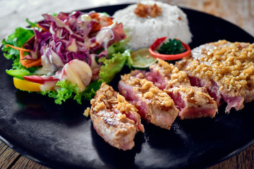 Grilled tuna steak with rice and vegetables. Close up.