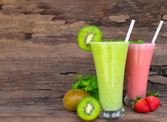 Kiwi and strawberry smoothies fruit juice green and red beverage healthy the taste yummy In glass drink episode morning on wooden background.