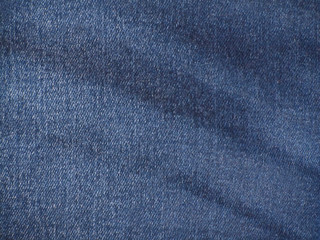 Light blue grunge background. Blue denim texture. Texture of worn faded jeans. Old denim texture.