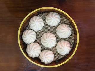A steamed bun is placed on a wooden board