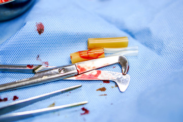 Used umbilical cord scissor and surgical forceps equipment after surgery completed on blue...