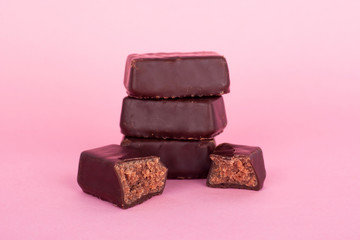 chocolate candies on a pink background. natural cocoa and melted milk chocolate sweets close up.