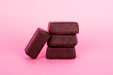 chocolate candies on a pink background. natural cocoa and melted milk chocolate sweets.