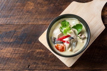 Coconut milk soup with chicken on cuting board,  Thai food that is popular in Thailand.; top view