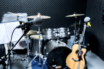Professional condenser studio microphone, Musical Concept. recording,microphone in radio studio, selective focus microphone and blur musical equipment guitar ,bass, drum piano background.