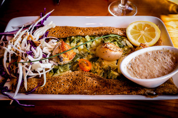 Traditional Galette bretonne with scallops from Brittany, France. Breton galettes are pancakes made with buckwheat flour usually with a savoury filling and popular in Bretagne.