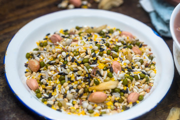 The white container holds the raw material of the eight treasures grain porridge on the board