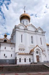 Fototapeta na wymiar The Golden dome of the Church of the Holy Martyr Grand Duchess Elisabeth in Khabarovsk in the summer against the blue sky and clouds
