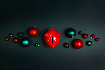 Piggy bank and christmas balls on black background. Saving money for Xmas.