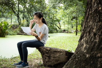 Sad asian child girl sit alone and crying,reading letter,bad news,female teenage student received school notice letter to her about her academic performance slump,disappointed with her education