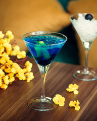 blue cocktail with ice and lemon zest