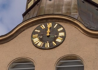 eine Kirchturmuhr schlägt 12 Uhr