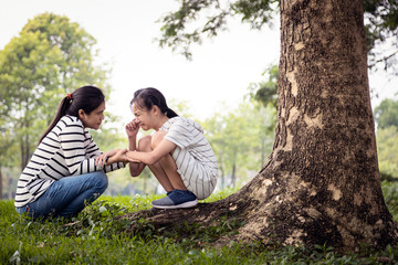 Stressed asian child girl sitting crying and thinking about problems at park,sad female teenage having psychological trouble with depressive symptoms feel despair,depression, sorrow,mental disorder